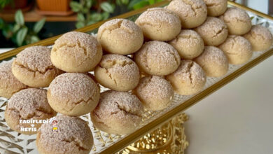 Tarçın ve pudra şekeri serpilmiş, çatlak yüzeyli minik kurabiyeler